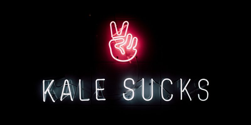 Vegan hero image: Neon 'Kale Sucks' sign on a black background